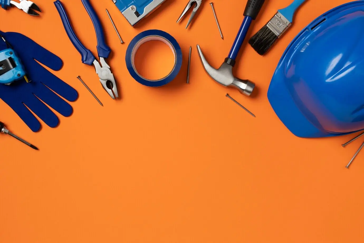 Overhead view of a steel hammer with other construction elements and tools.