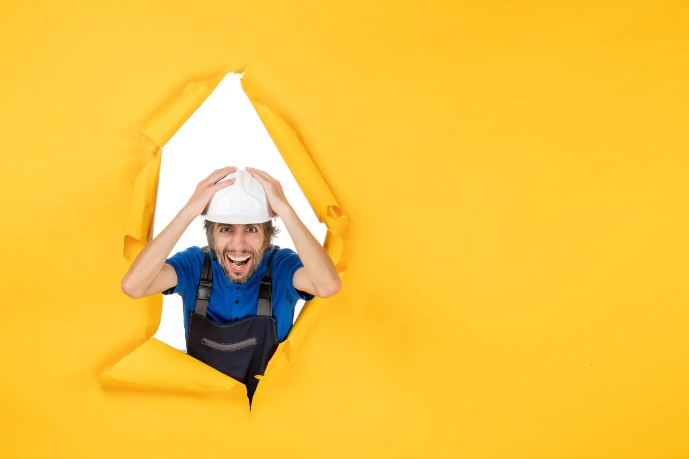 Front-facing view of a male construction worker in uniform against a yellow background.